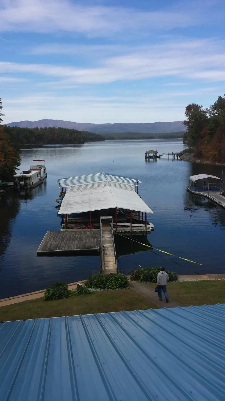 View across a lake from a newly installed blue metal roof in Barclay